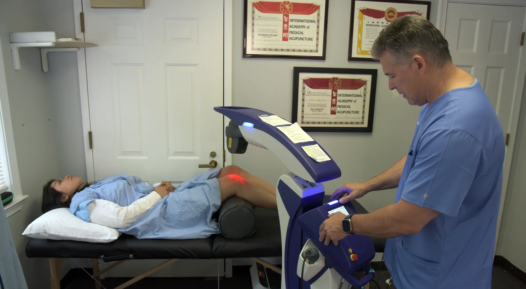 Chiropractor Herndon VA Chris Oliver With Patient On Laser Therapy